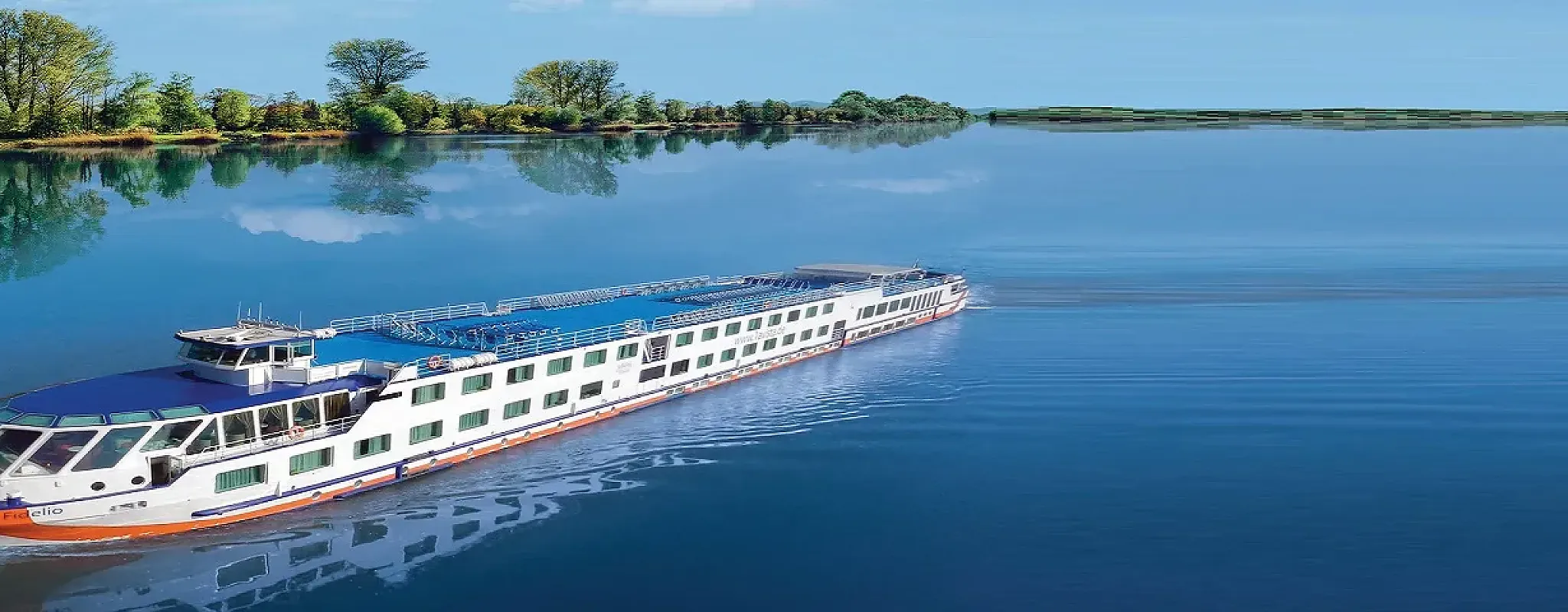 Flusskreuzfahrtschiff auf ruhigem Wasser, umgeben von Natur.