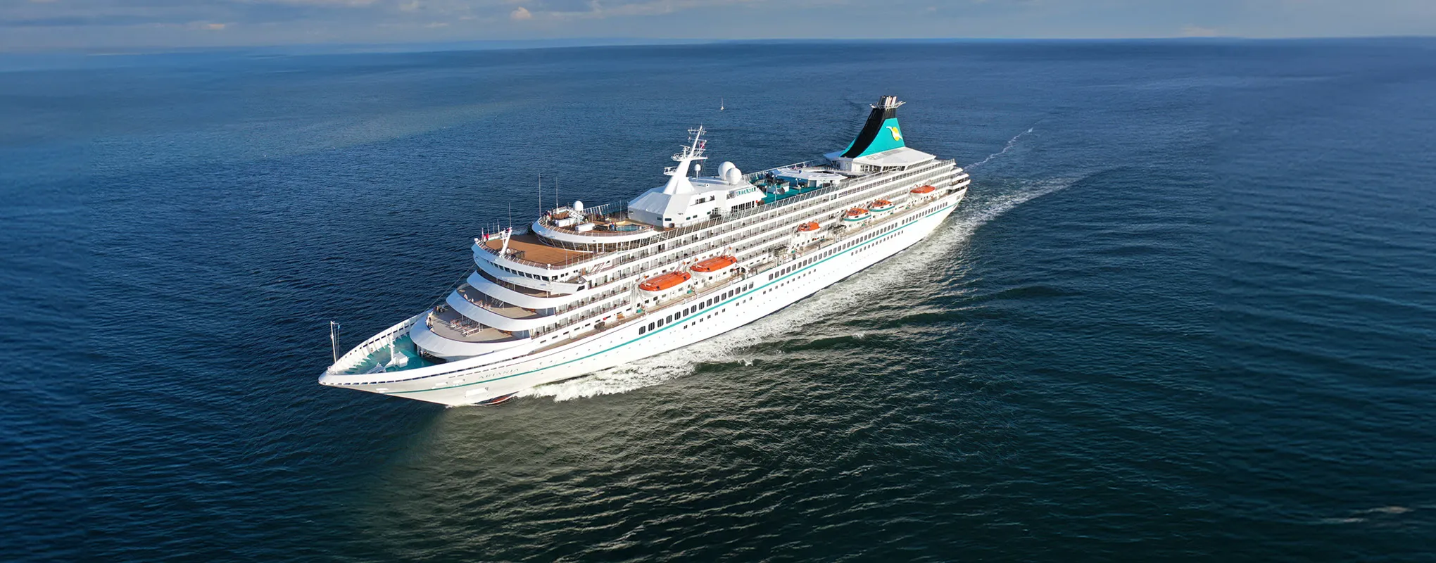 Kreuzfahrtschiff auf offenem Meer bei sonnigem Wetter.