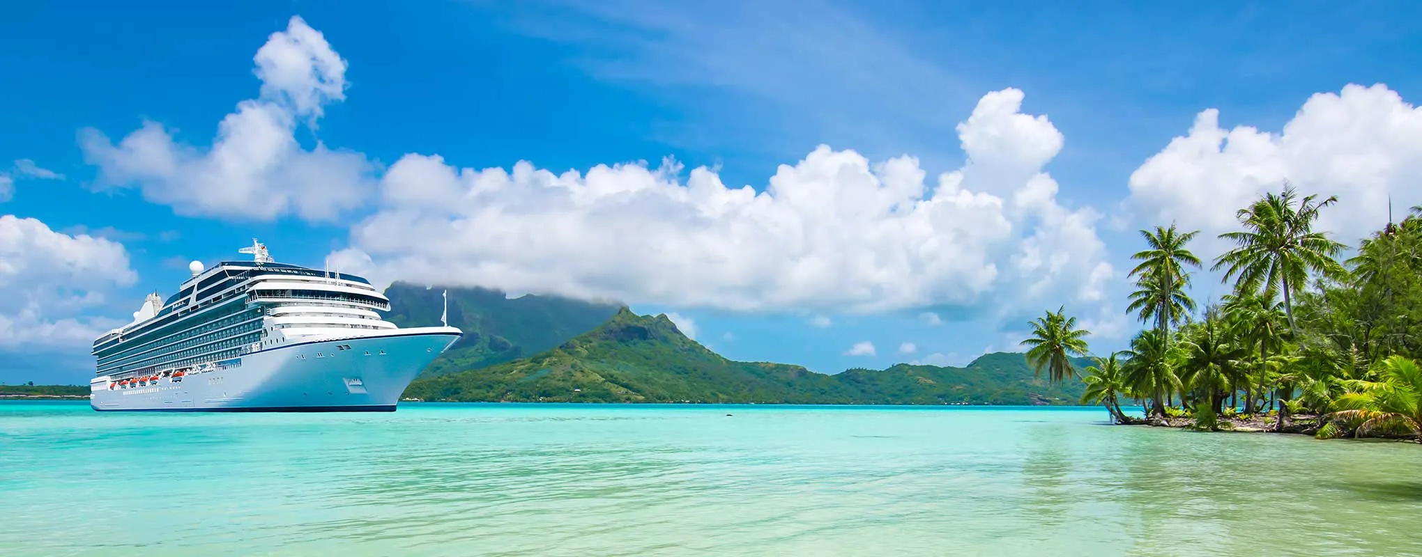 Kreuzfahrtschiff im tropischen Paradies mit Palmen und Bergen.