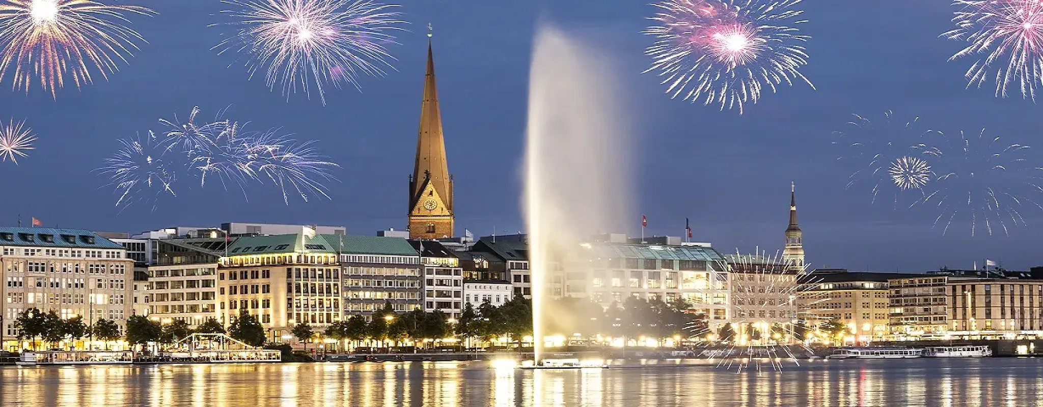 Feuerwerk über beleuchteter Stadt am Wasser in festlicher Stimmung.