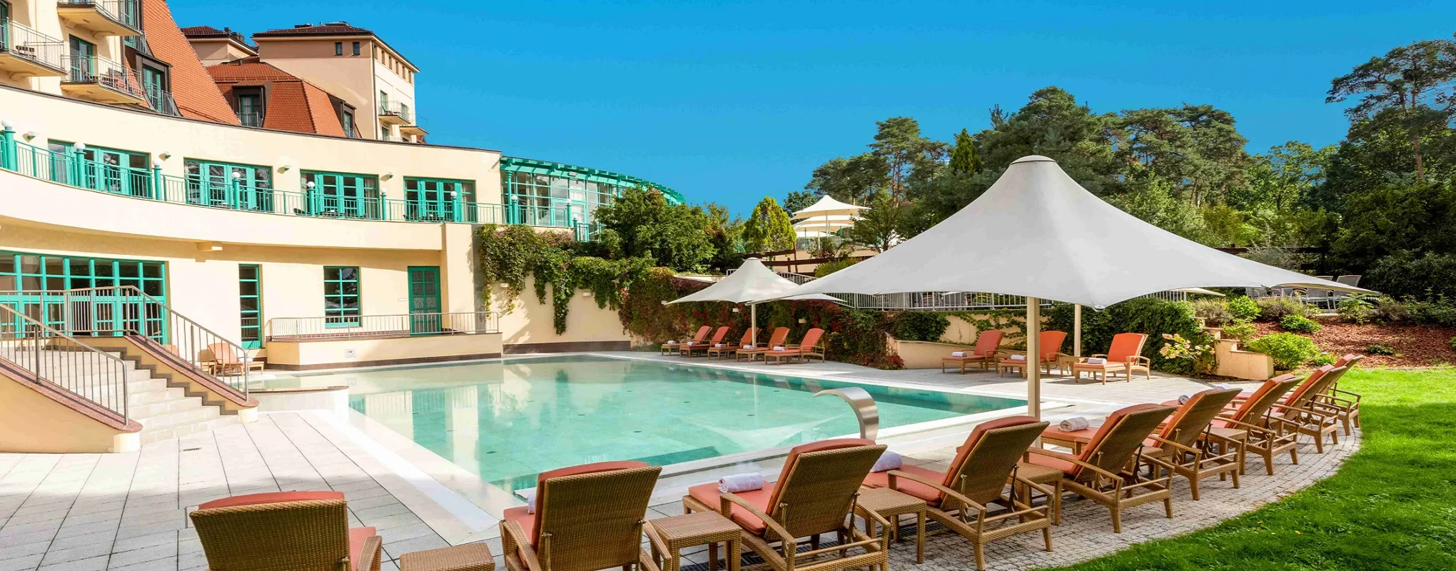 Luxuriöser Poolbereich im Resort mit Liegen und Sonnenschirmen.