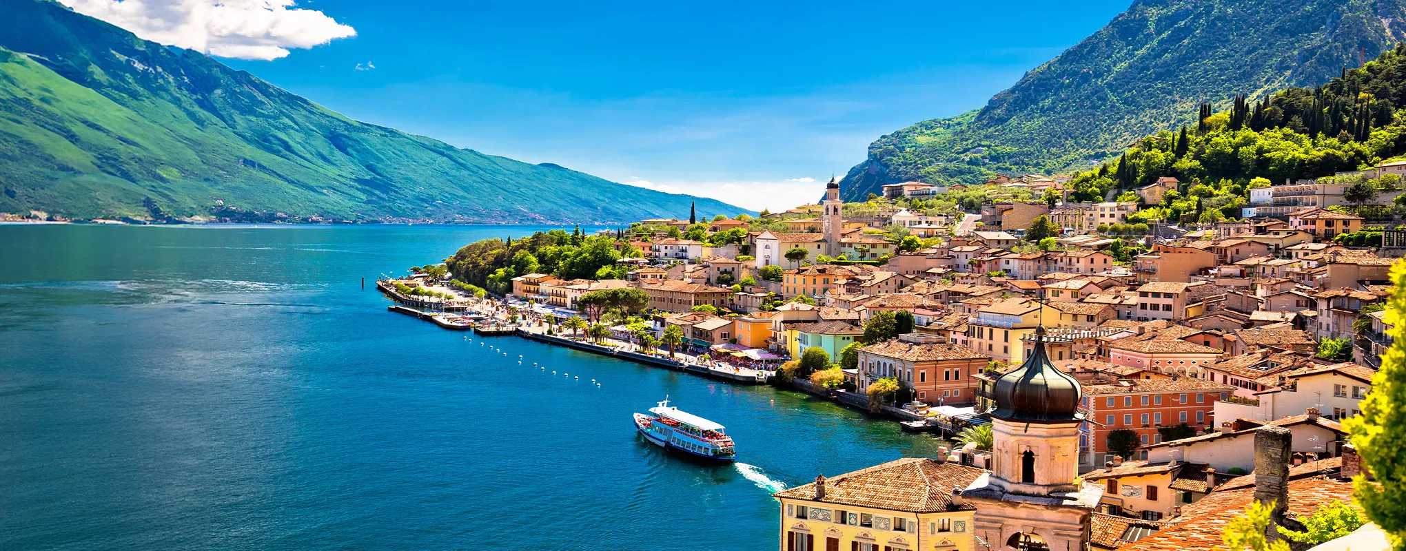 Italienische Küstenstadt am See, umgeben von Bergen und Natur.