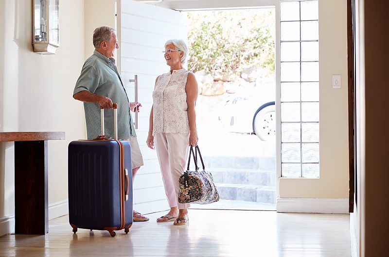 Älteres Paar kehrt glücklich von der Reise zurück.