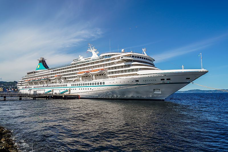 Kreuzfahrtschiff Artania im Hafen bei strahlend blauem Himmel.