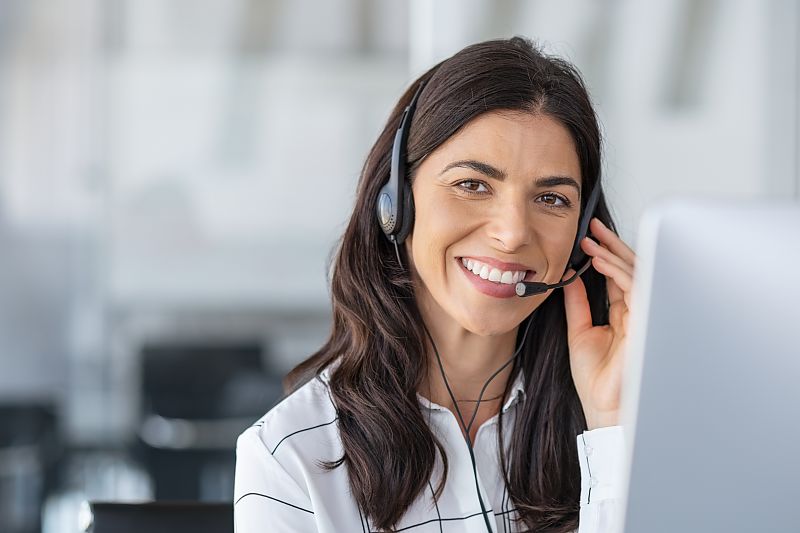 Freundliche Kundenberaterin mit Headset im Gespräch.