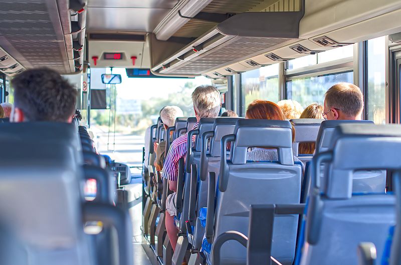 Busfahrt bei Sonnenschein, entspannte Reisende unterwegs.