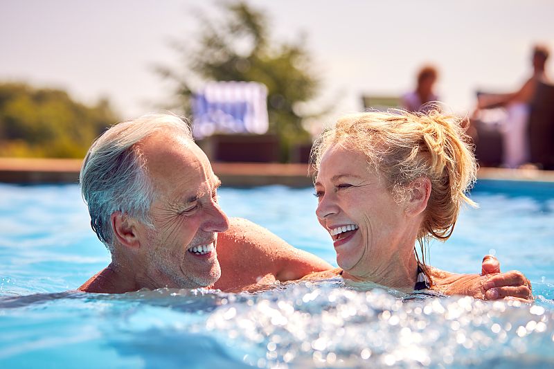 Glückliches Paar genießt entspanntes Bad im sonnigen Pool.