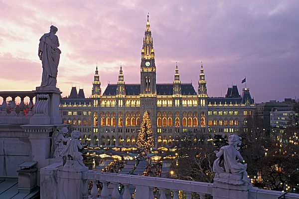 Wien, Christkindlmarkt, Wiener Rathaus bei Dämmerung, festlich beleuchtet im Advent.