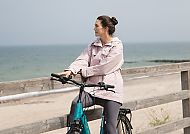 Frau  mit Fahrrad am Meer