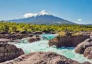 Schneebedeckter Vulkan über Fluss und Felsen in Chile.