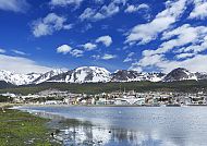 Blick auf Ushuaia vor schneebedeckten Bergen und blauem Himmel.