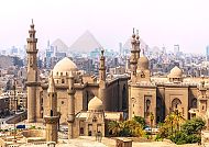 Historische Moschee und Pyramiden in Kairo bei klarem Himmel.