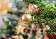 Goldene Christbaumkugel an Tannenzweig, festliche Stimmung.