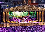 Open-Air-Konzert mit Orchester und Publikum bei Nacht.