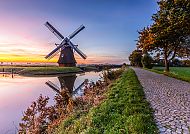Windmühle in Holland bei Sonnenuntergang, idyllische Landschaft.