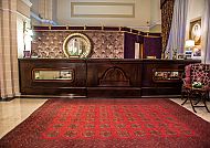 Elegante Hotelrezeption mit luxuriösem Teppich und stilvollem Dekor.