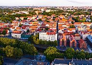 Blick über Klaipeda: Rote Dächer und grüne Bäume im Abendlicht.