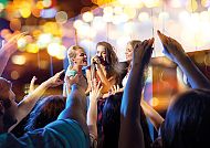 Karaoke-Show, Karaoke-Show mit begeistertem Publikum und festlicher Stimmung., Karaoke-Show mit fröhlicher Menge und bunten Lichtern.