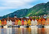 Bergen, Bunte Häuserzeile in Bergen, Norwegen, vor grüner Bergkulisse., Bunte Häuserzeile am Hafen von Bergen vor grünen Hügeln.