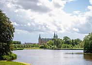 Schloss Frederiksborg, Schloss Frederiksborg hinter einem malerischen See und üppigem Grün., Schloss Frederiksborg vor malerischer Seenlandschaft in Dänemark.