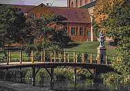 Odense, Herbstliche Idylle in Odense mit Brücke und Statue., Herbstliche Brücke in Odense mit Statue und Backsteingebäude.