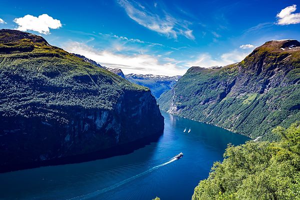 Geiranger, Majestätischer Geirangerfjord im Sommer, umgeben von grünen Bergen.
