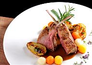Elegantes Abendessen, Elegantes Abendessen mit Lammkoteletts und buntem Gemüse., Elegantes Lammgericht mit Gemüse und Kräutergarnitur.
