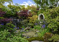 , Üppiger Garten mit Wasserfall und bunten Blumen bei der Chelsea Flower Show.