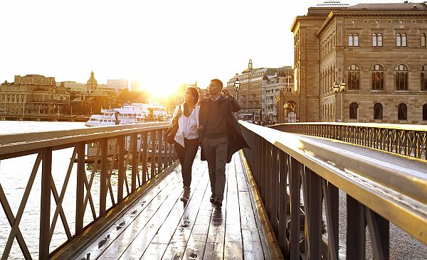 Stockholm - Skeppsholmbron, Paar spaziert bei Sonnenuntergang über die Skeppsholmbron in Stockholm., Paar spaziert bei Sonnenuntergang über die Skeppsholmbron in Stockholm.