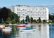 Superior Parkhotel, Superior Parkhotel am Wörthersee mit Segelbooten im Vordergrund., Superior Parkhotel am Wörthersee mit Segelbooten im Frühling.