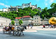 Salzburg, Festung Hohensalzburg überblickt lebhaften Residenzplatz in Salzburg., Salzburg im Frühling: Pferdekutsche vor der Festung Hohensalzburg.