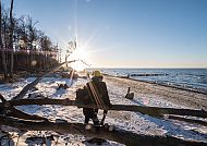 Ostseestrand im Winter, Winterlicher Ostseestrand im Sonnenlicht mit Pärchen.