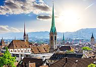 Zürich, Zürichs Skyline mit Großmünster und Alpen im Hintergrund., Zürichs Altstadt mit Kirchtürmen und Alpenpanorama im Hintergrund.