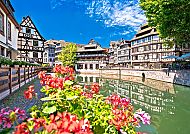 Straßburg, Malerische Fachwerkhäuser und Blumenpracht in Straßburg., Malerische Fachwerkhäuser und Blumen am Wasser in Straßburg.