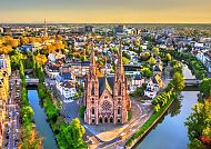Straßburg, Luftaufnahme der Kirche Saint-Paul in Straßburg, umgeben von Wasser., Straßburgs beeindruckende Architektur im goldenen Abendlicht.