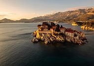 Sveti Stefan im Abendlicht, umgeben von Meer und Bergen
