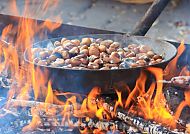 Röstende Kastanien über offenem Feuer beim Kastanienfest