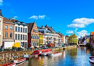 Bunte Häuser und Boote an einem sonnigen Kanal in Gent.