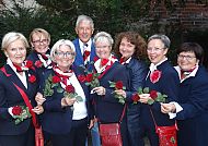 Rote Rosen Gruppe, Gruppe von Menschen mit roten Rosen in Lüneburg., Gruppe lächelnder Menschen mit roten Rosen in Lüneburg.