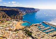 Küstenblick auf Puerto de Mogán, Gran Canaria, mit Yachthafen., Hafen und Küste von Gran Canaria bei sonnigem Wetter