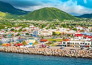 St. Kitts & Nevis, Bunte Küstenstadt vor grünen Hügeln auf St. Kitts & Nevis., Blick auf die malerische Küste von St. Kitts, Karibik.