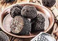 Frische schwarze Trüffel auf einem rustikalen Holztisch