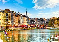 Honfleur, Malerischer Hafen von Honfleur mit bunten Gebäuden und Booten., Bunte Hafenansicht von Honfleur mit historischen Gebäuden.