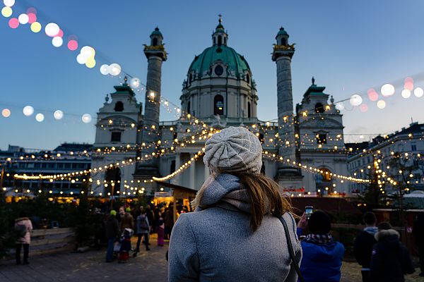 Wien Kunst-Weihnachtsmarkt, Weihnachtsmarkt vor der Karlskirche in Wien bei Abenddämmerung.
