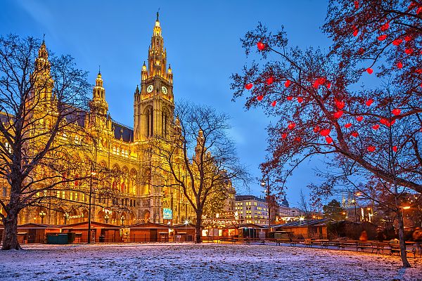 Wien, Wiener Rathaus im Winterzauber, festlich beleuchtet bei Dämmerung.
