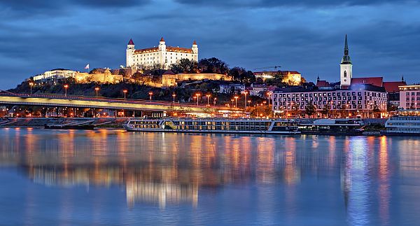 Bratislava, Bratislava bei Nacht, beleuchtete Burg und Donau im Vordergrund.