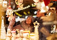 Weihnachten, Paar genießt festliche Stimmung auf einem Weihnachtsmarkt., Paar genießt festlichen Weihnachtsmarkt an der Donau.