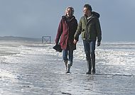 Paar im Herbst am Strand von Norderney, Paar spaziert im Herbst am Strand von Norderney., Paar genießt herbstlichen Spaziergang am Strand von Norderney.