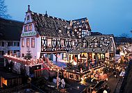 Rüdesheimer Weihnachtsmarkt bei Abenddämmerung, festlich beleuchtet.