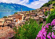 Riva del Garda: Malerische Aussicht auf den Gardasee und die Alpen., Malerische Dächer und blühende Gärten.